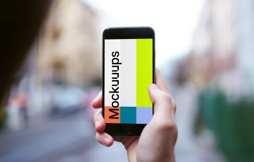 Holding iPhone 6 mockup on the street