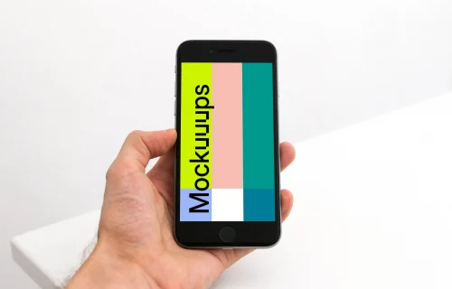 Holding iPhone 6s mockup in the office