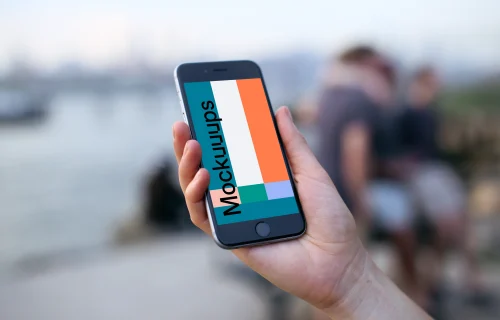 Holding iPhone 6s mockup next to the river