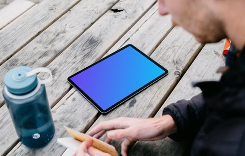 iPad Air mockup on a park table beside a water bottle