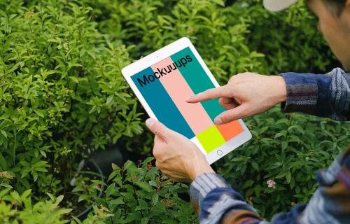 iPad Mini mockup held by a user in a garden 