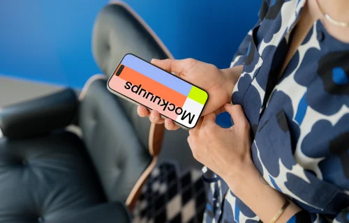 iPhone 15 Pro mockup in woman's hand against blue background
