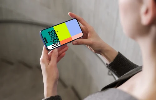 iPhone 16 mockup in a hand against concrete backdrop