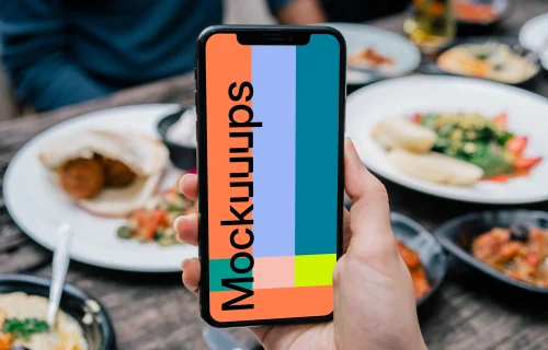iPhone mockup held at lunch table
