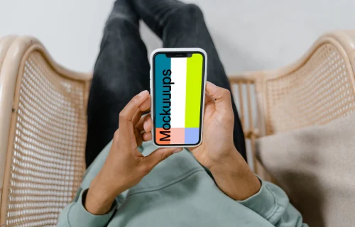 iPhone mockup held by user in a chair 