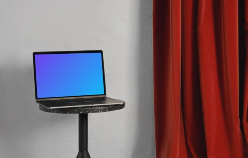 MacBook mockup on a black stool with red curtain in the background