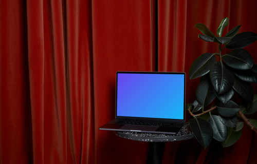 MacBook mockup on a stool beside flower pot