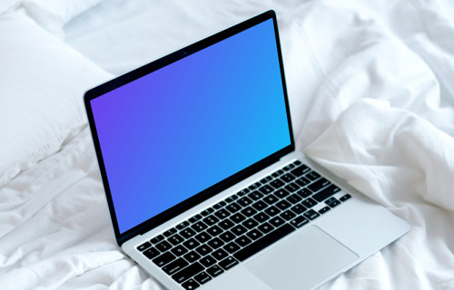 MacBook mockup on a white bed with coffee on a saucer