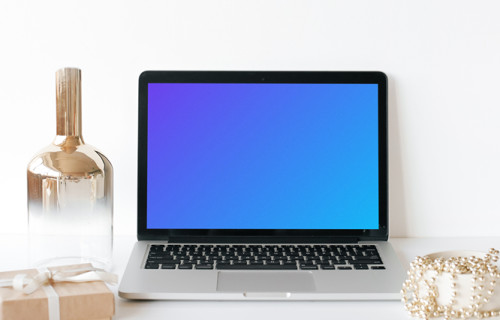 MacBook mockup on a white table with a glass jar at the side