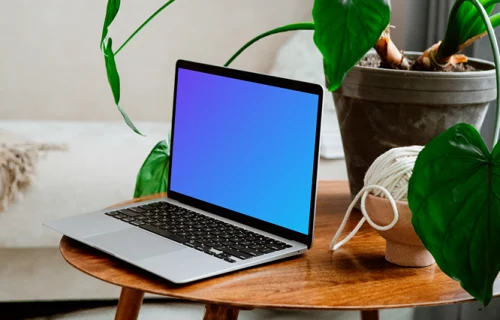 MacBook mockup on a wooden table with flower pot