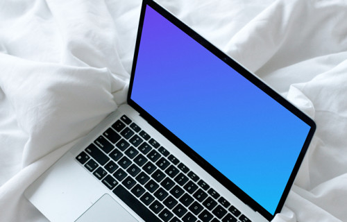 MacBook mockup resting on a white bed