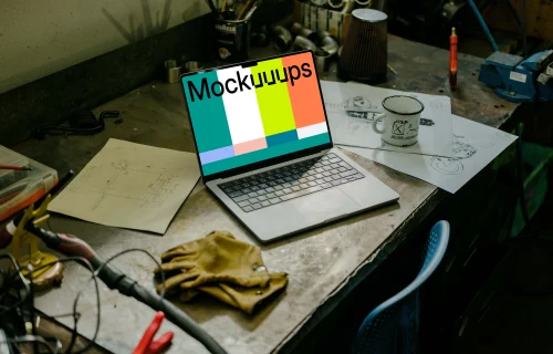 MacBook Pro mockup placed on a table beside work gloves