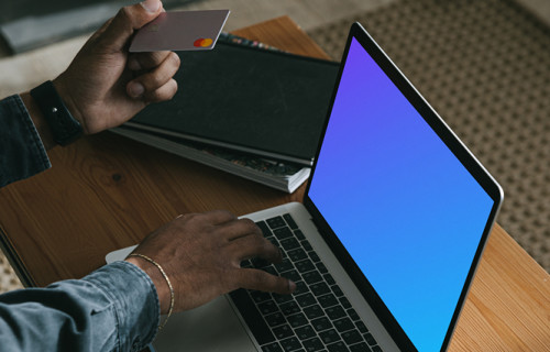 Man entering credit card details on a MacBook Pro mockup