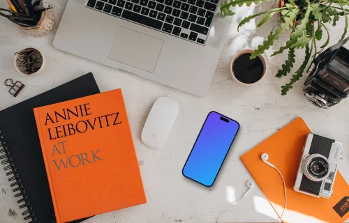 Mockup of smartphone device with books and MacBook Pro