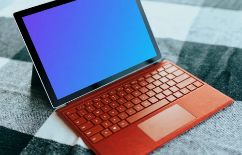 Red Microsoft Surface Laptop mockup on a bed