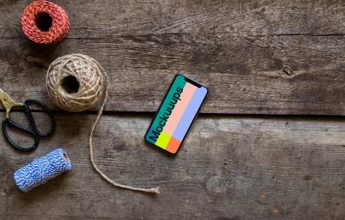 Rotated iPhone XS mockup with a scissors on the side