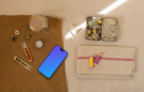 Smartphone mockup next to sewing accessories