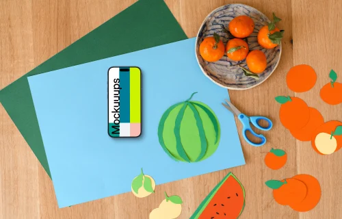 Smartphone mockup with colorful paper fruits on wooden surface