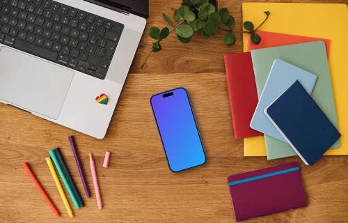 Smartphone mockup with rainbow pens and notebooks