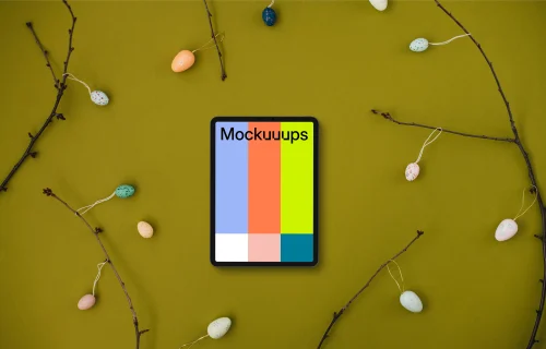 Tablet mockup among Easter eggs on branches