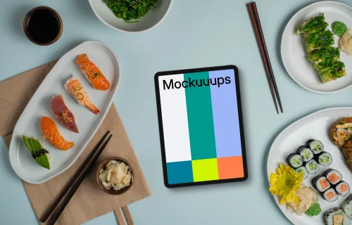 Tablet mockup between plates of sushi