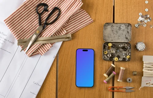 Top view of phone mockup with sewing accessories