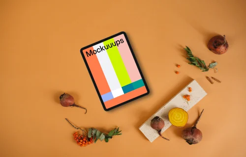 Top view of tablet mockup on the light orange background