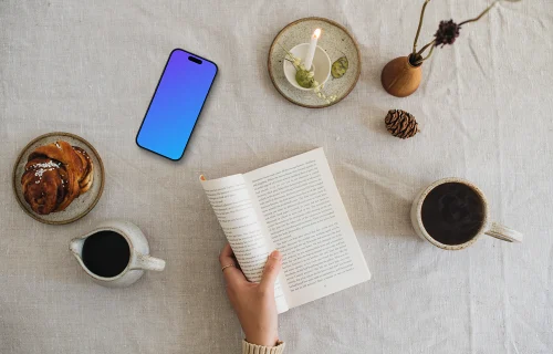 Top view of woman reading a book with smartphone on the side