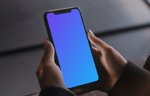 User holding an iPhone in both hands mockup