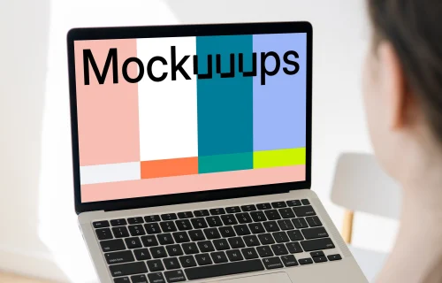 Woman holding a MacBook Pro mockup in a bright room