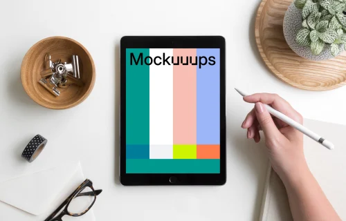 Woman holding Apple pencil over iPad Pro mockup