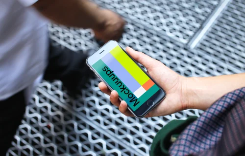 Woman holding iPhone 6s mockup on a bridge