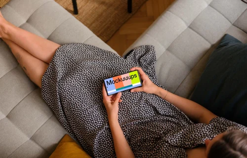 Woman laying on sofa holding a Google Pixel 6 mockup