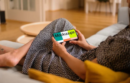Woman laying on sofa holding a Google Pixel mockup