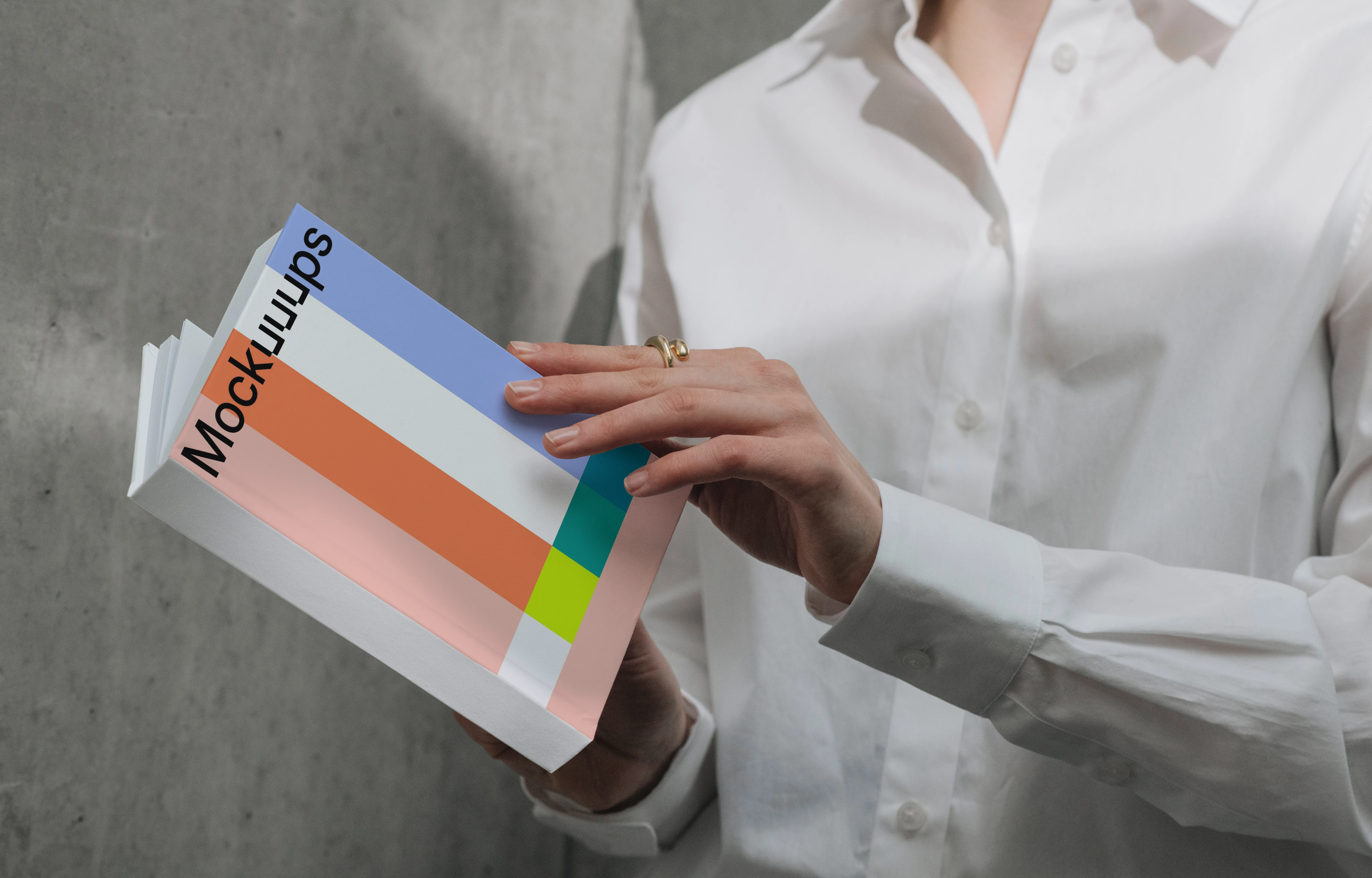 A-format book mockup held by person in white shirt