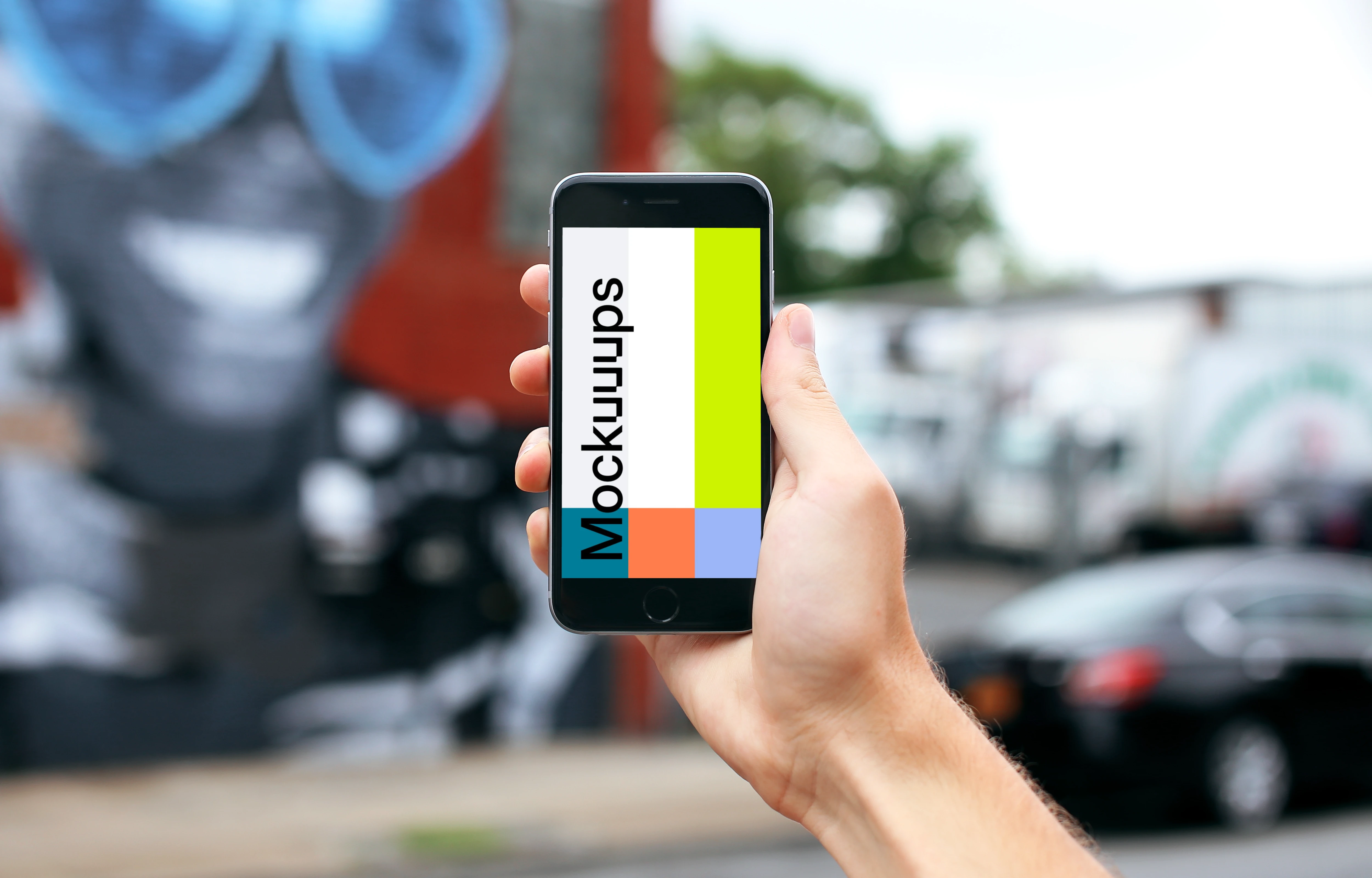 Holding iPhone 6s mockup in front Street Art
