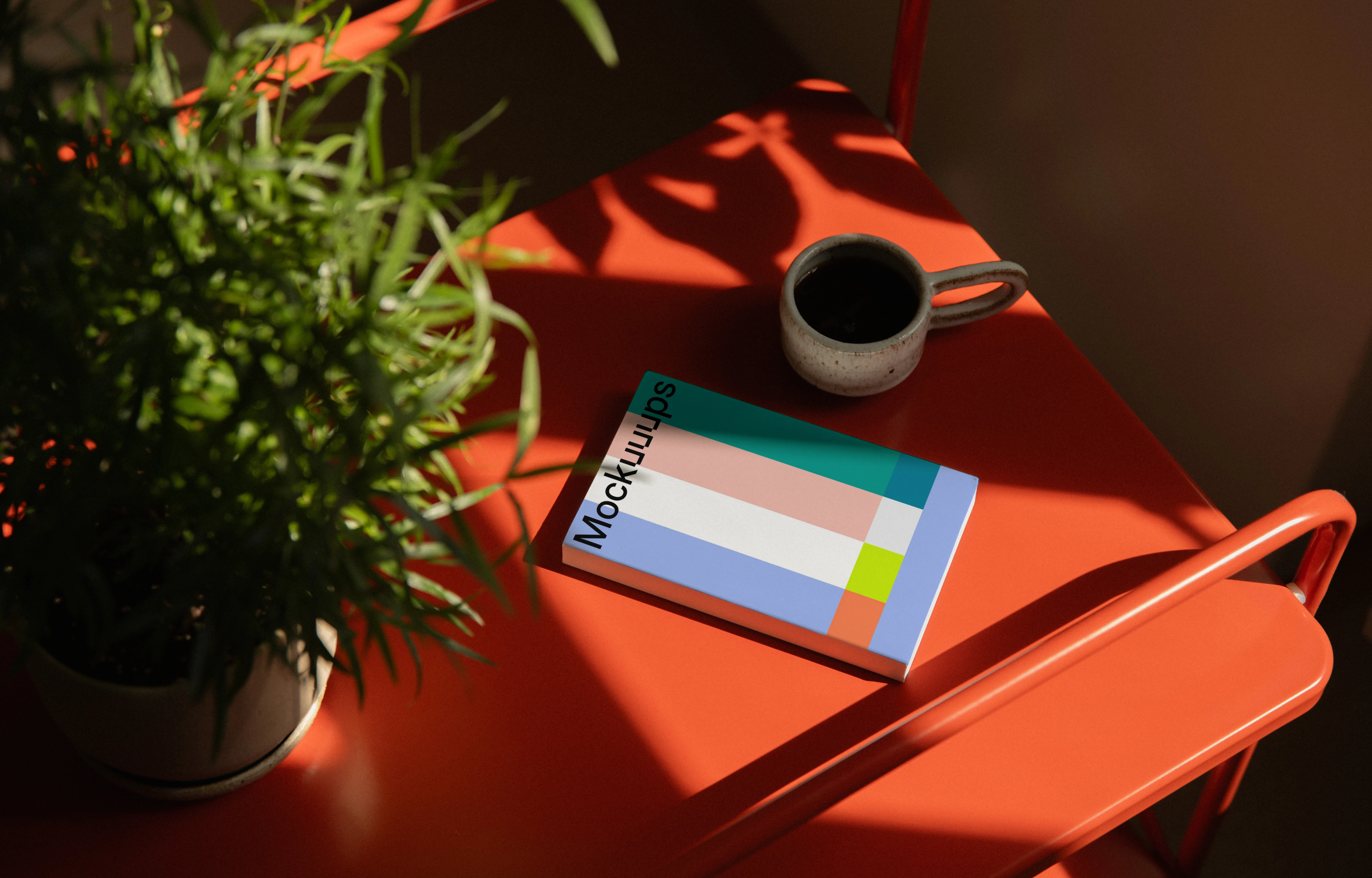 Paperback mockup on a bright red table with natural light