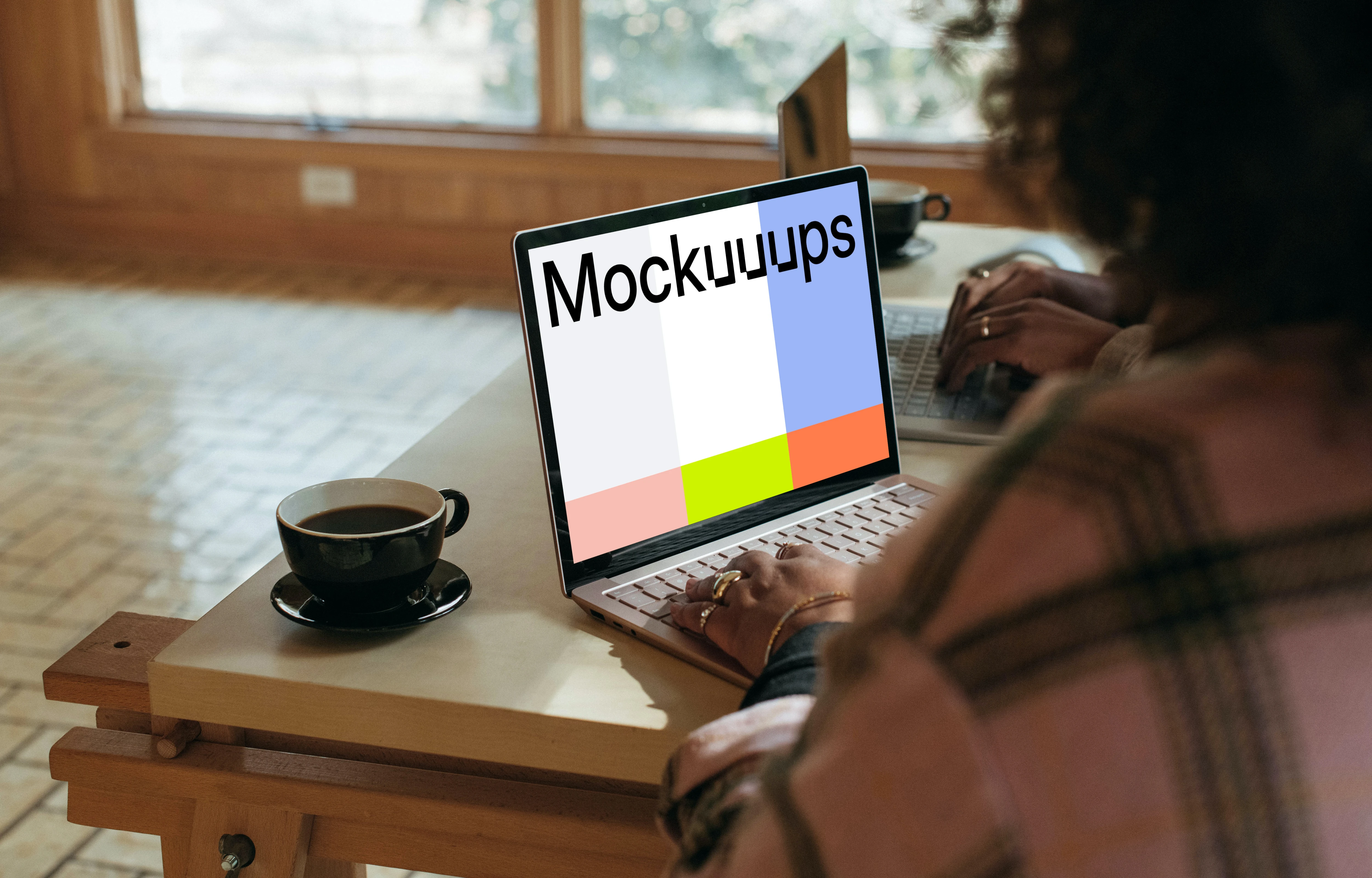 Sitting next to the colleague and working on the Microsoft Surface Laptop mockup