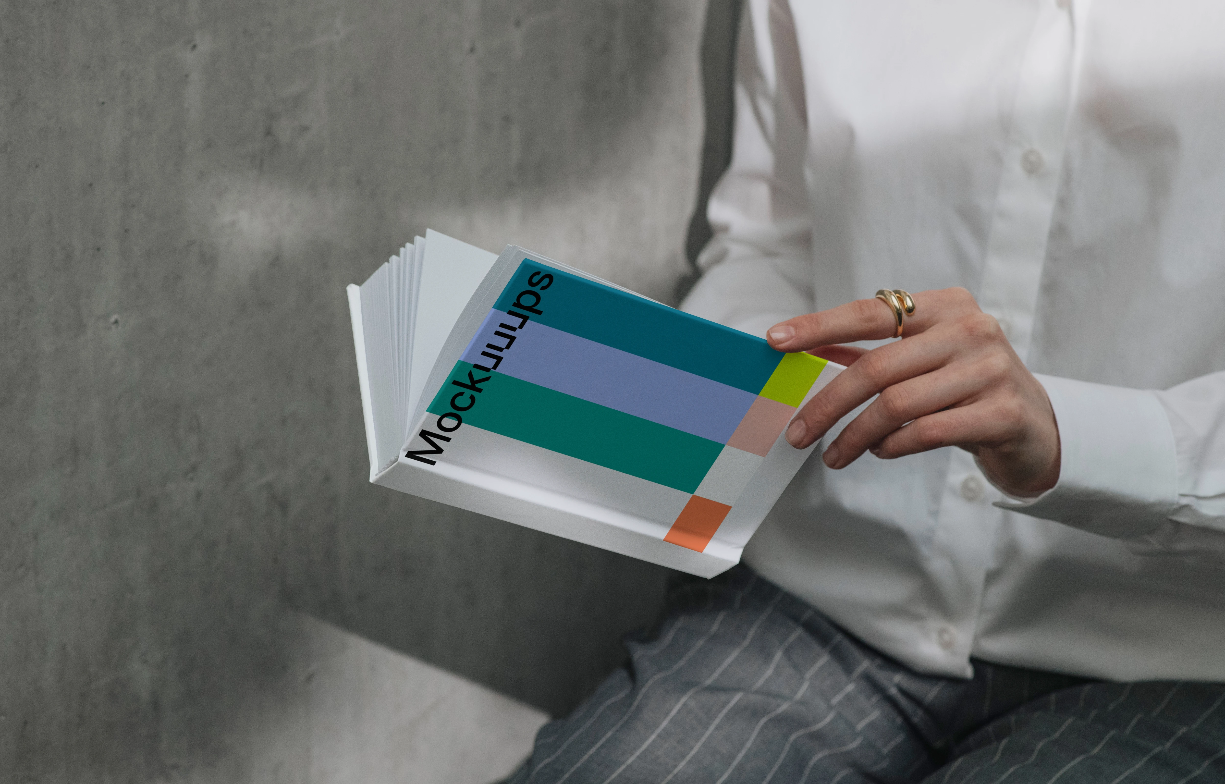 A-format book mockup in hands against concrete wall