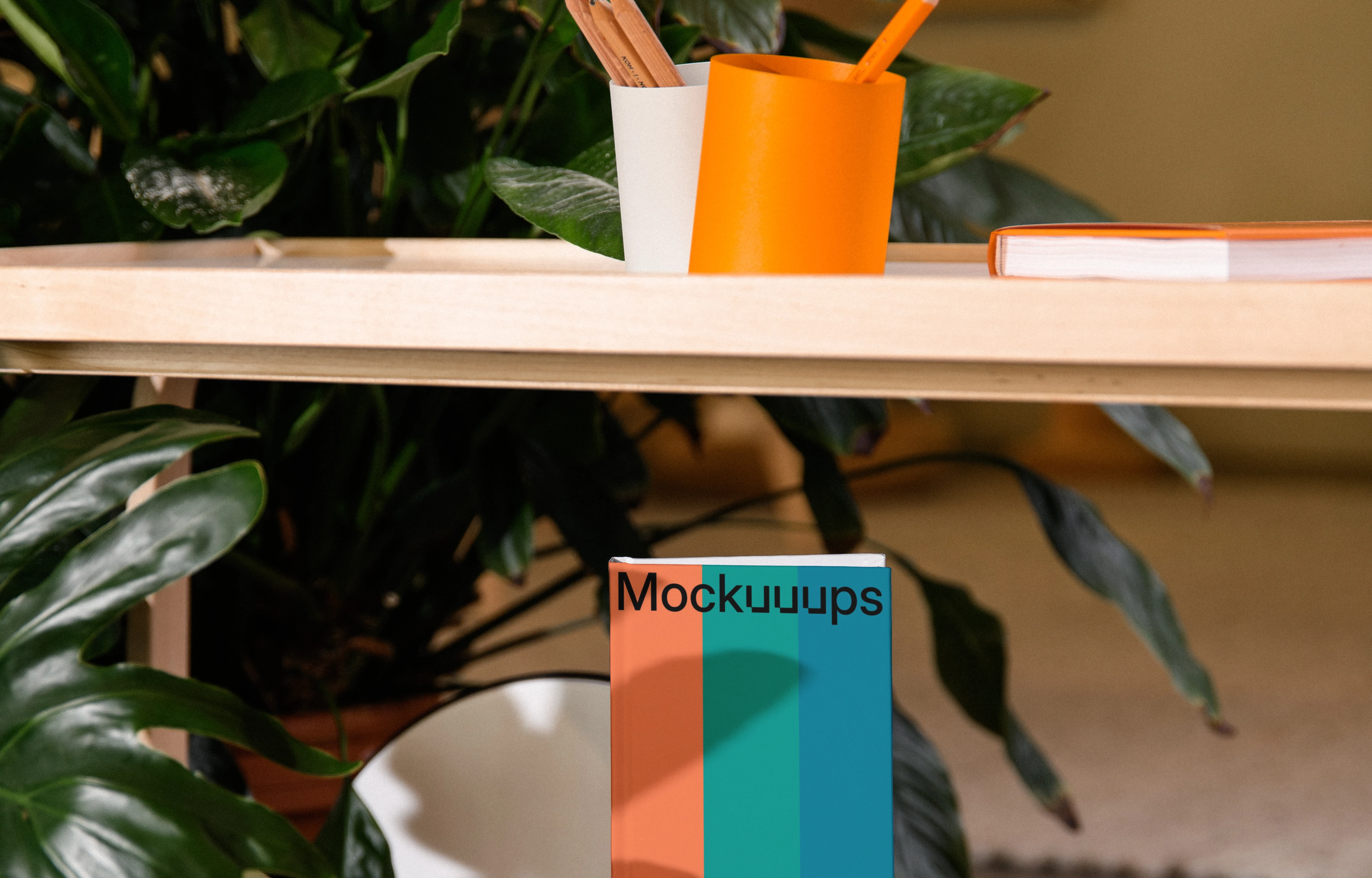 A-format book mockup on a wooden shelf with decor