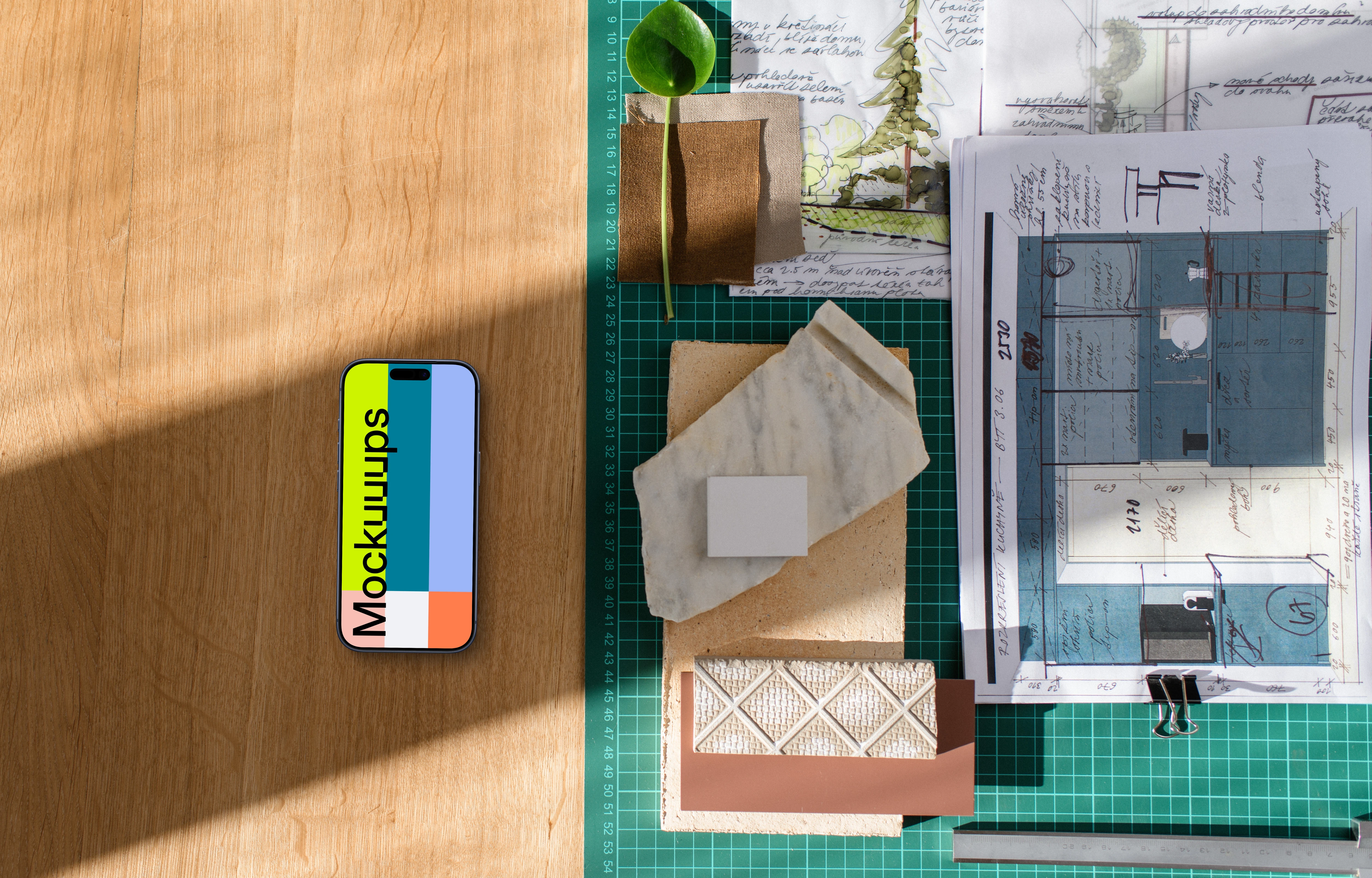 Architect's smartphone mockup on a wooden desk with blueprints