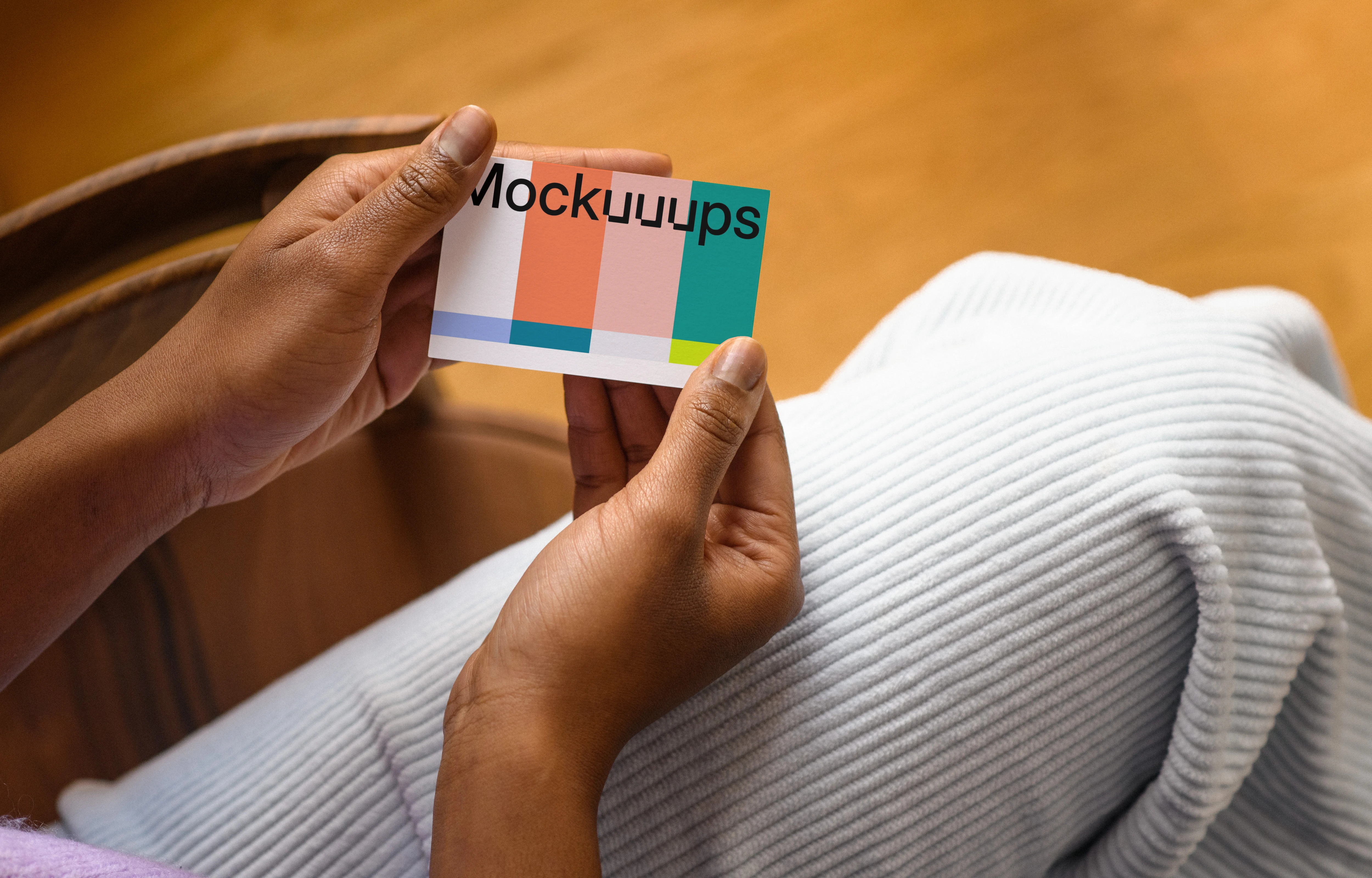 Business card mockup held by hands in a casual setting