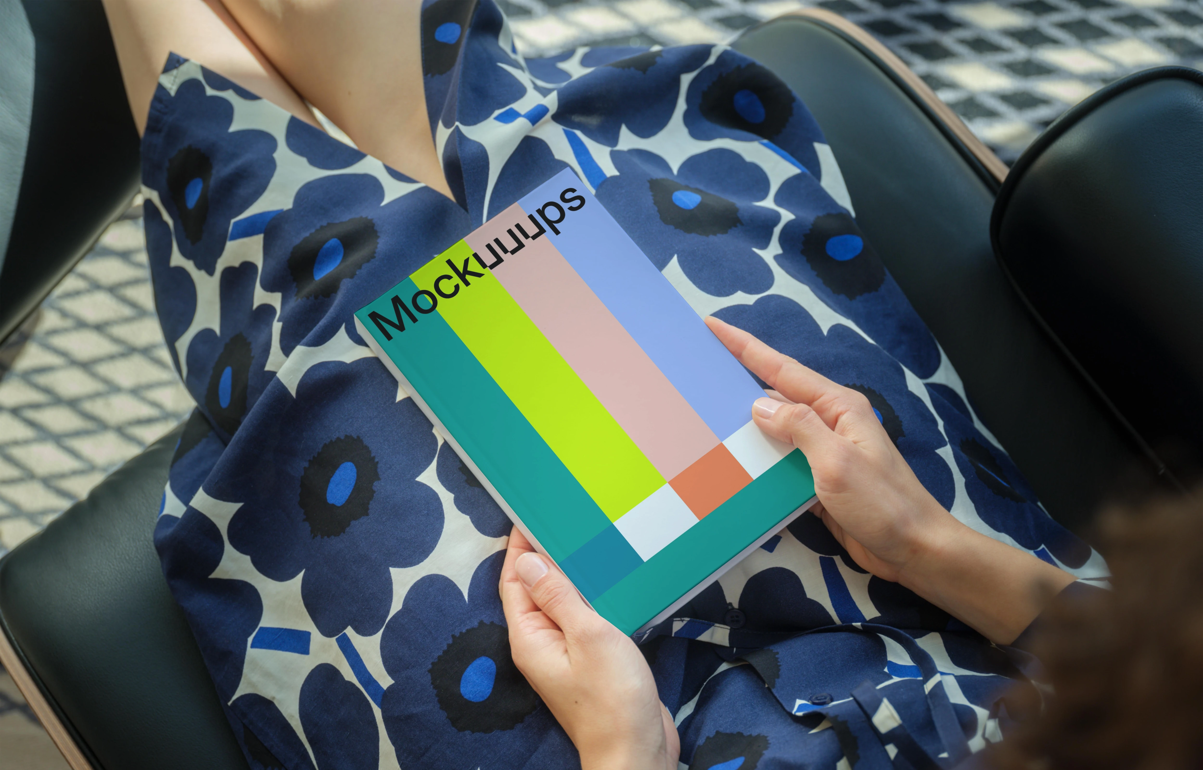 C-format book mockup held by a seated person