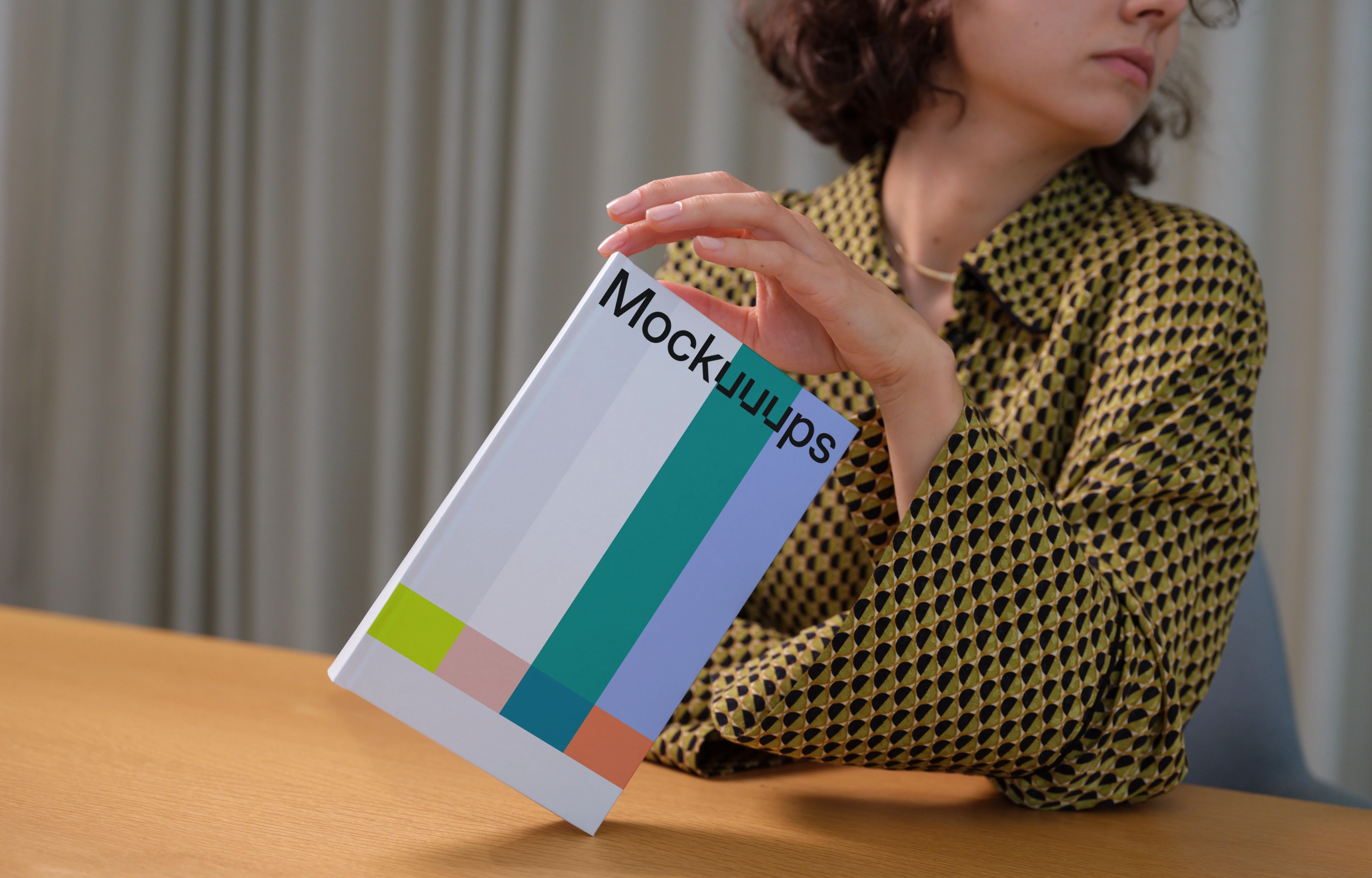 C-format book mockup held in a modern setting