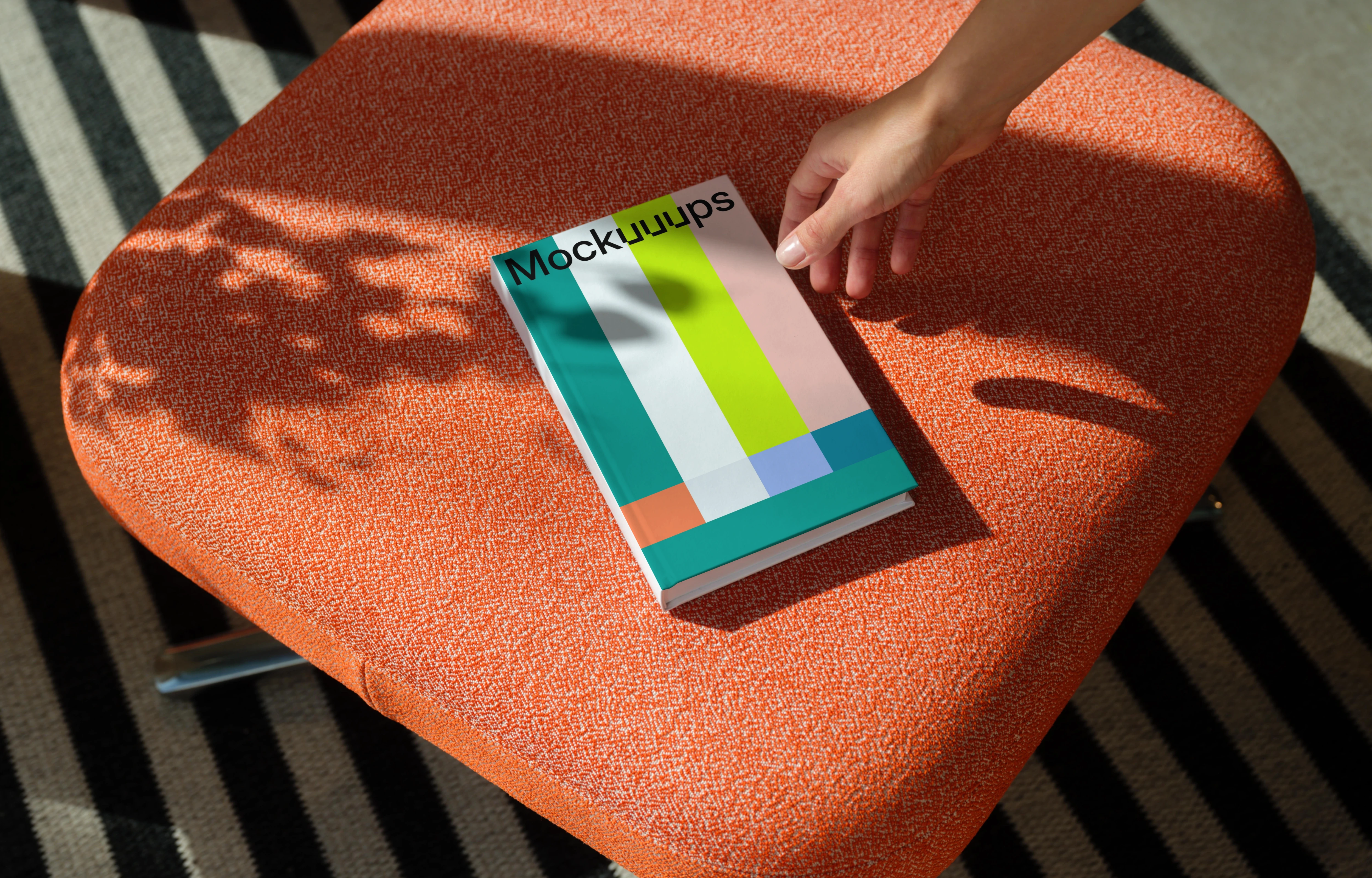 C-format book mockup on an orange fabric chair