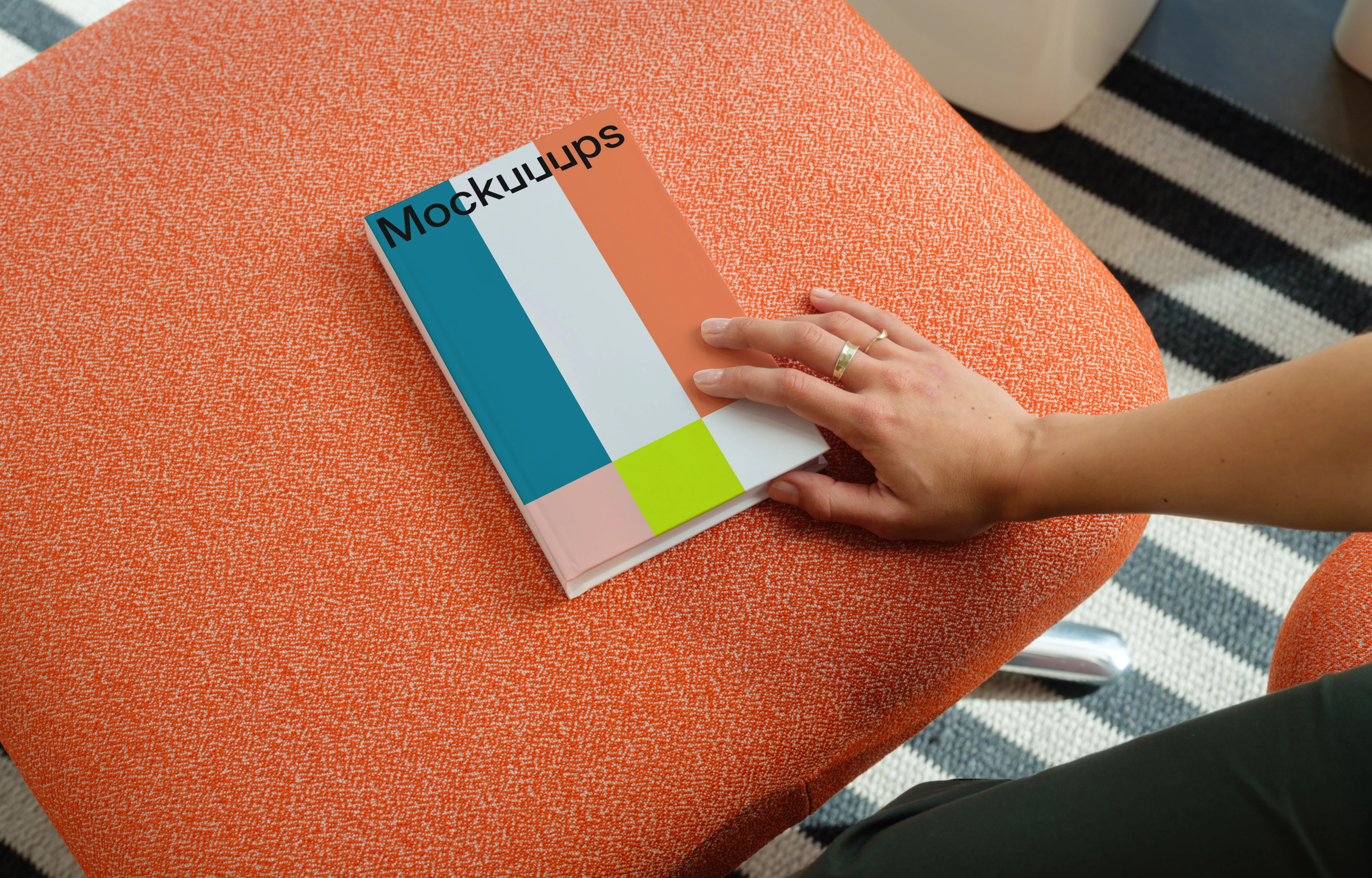 C-format book mockup on an orange ottoman