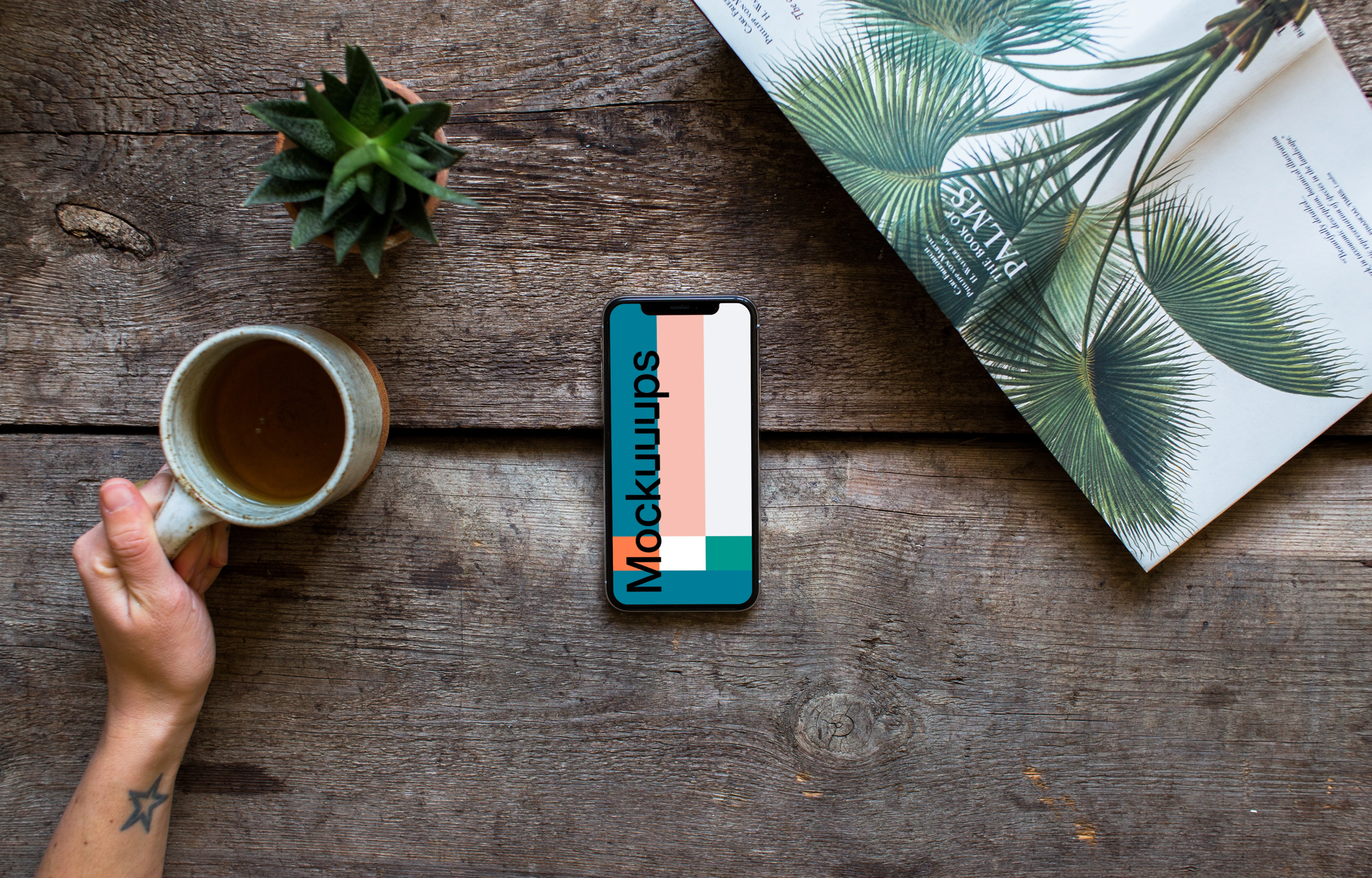 Drinking tea over the iPhone XS mockup and plants