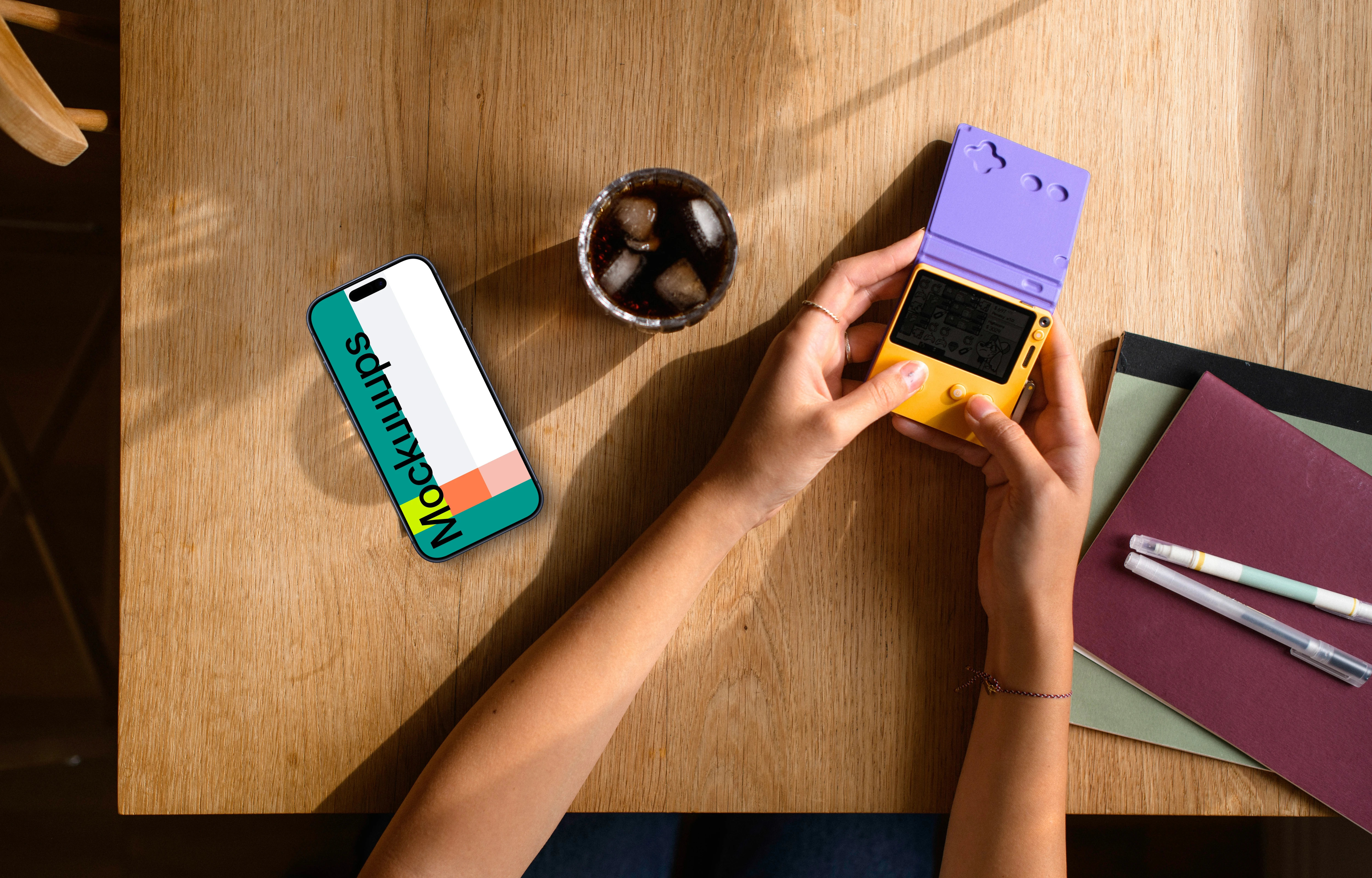 Smartphone mockup on wooden table with gaming handheld