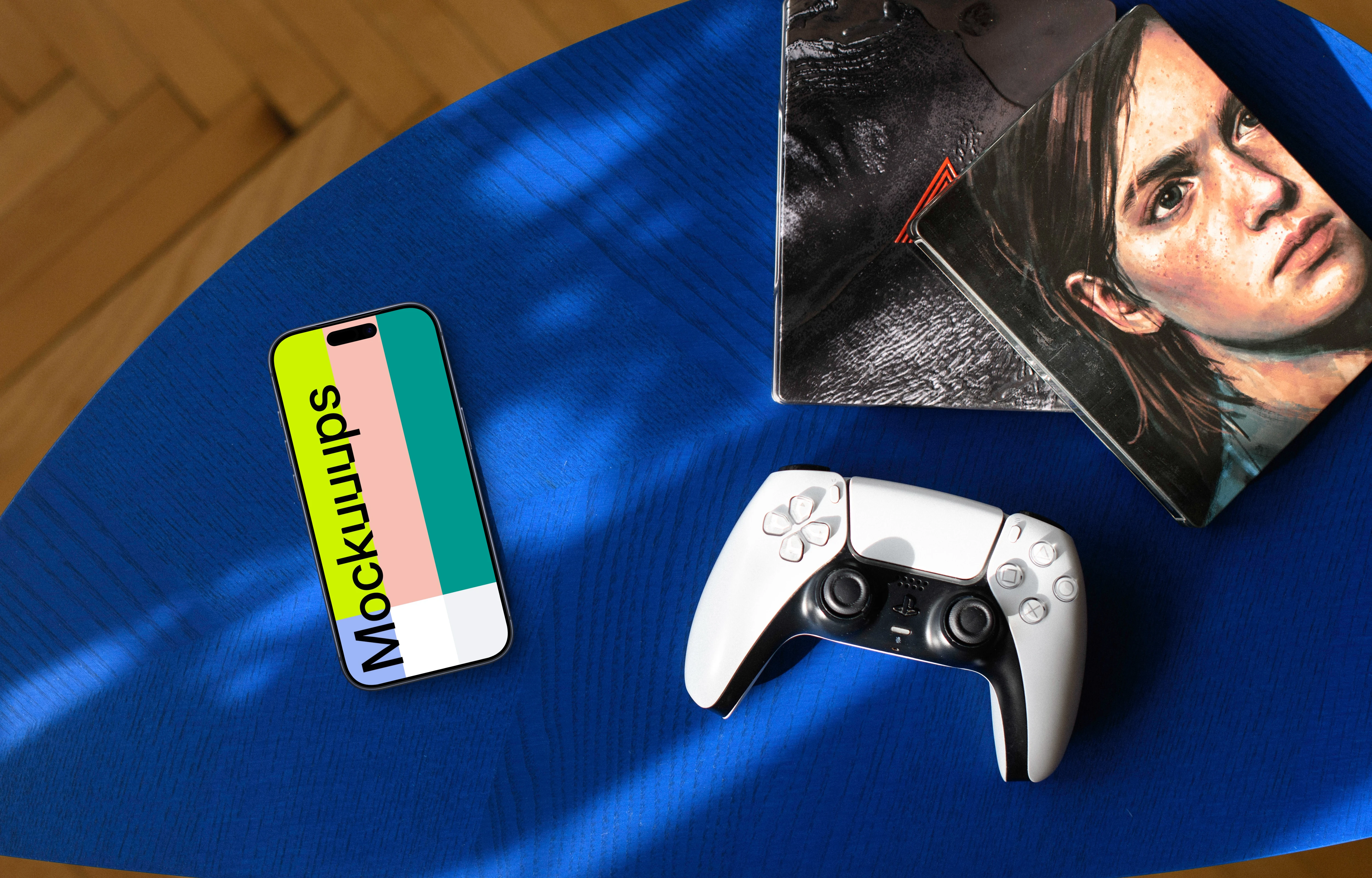 Gaming smartphone mockup with controller and artwork on blue table