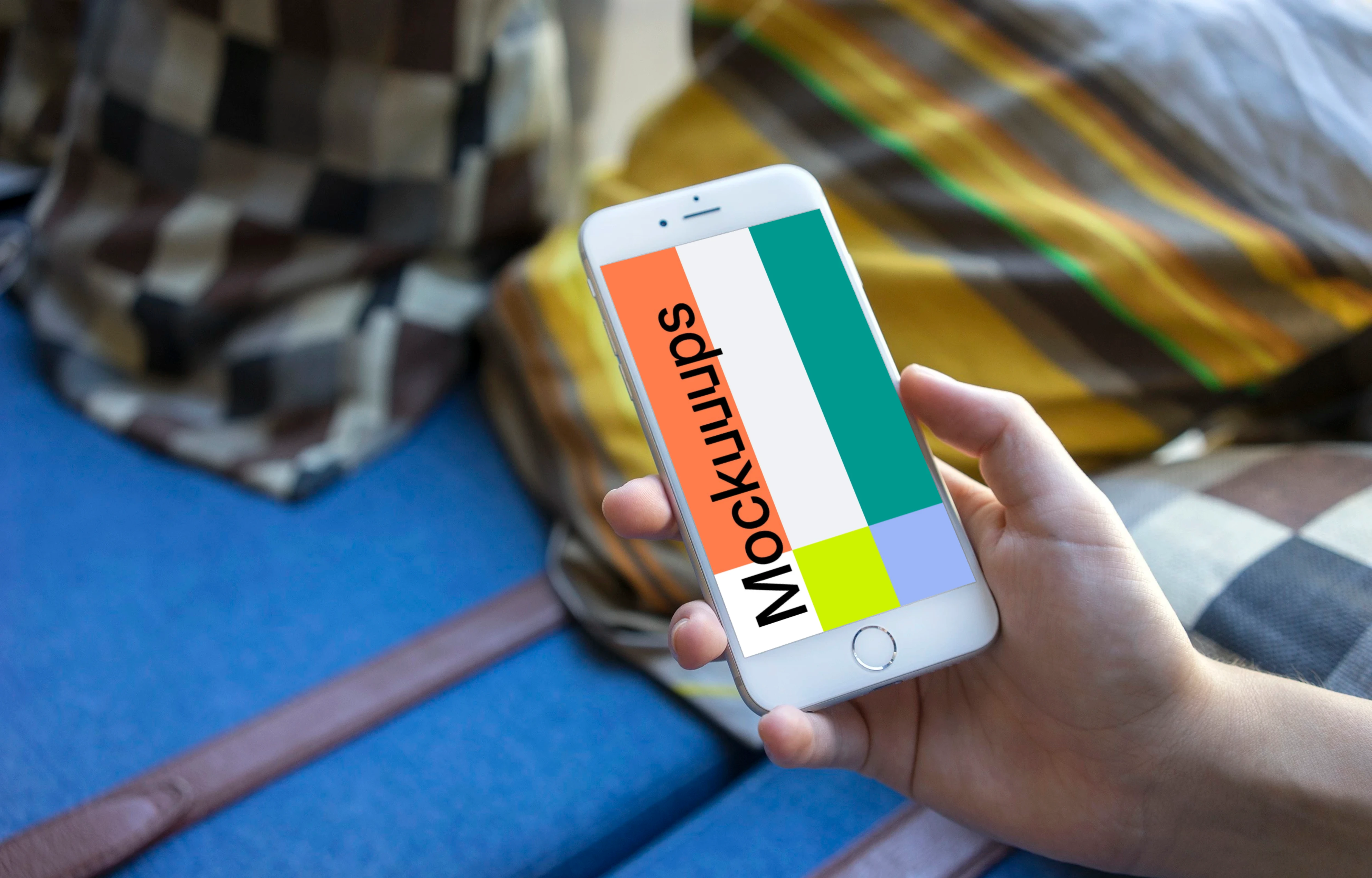 Holding iPhone 6 mockup on a Sofa with Pillows